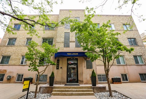 The front of a building with a blue sign that reads "1628 LOGAN".