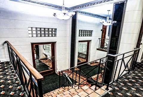 A staircase with a black railing and a patterned carpet.