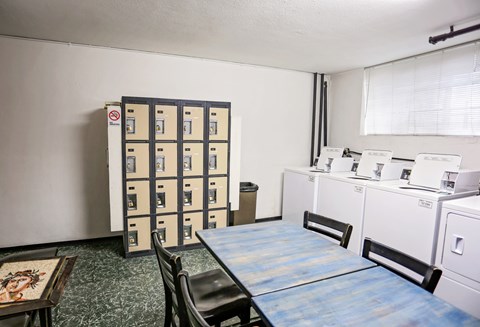 A room with a blue table and a cabinet with drawers.