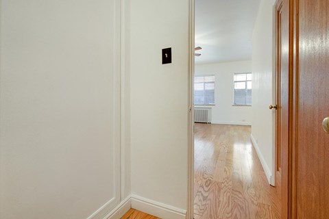 A room with a wooden floor and a door on the right.