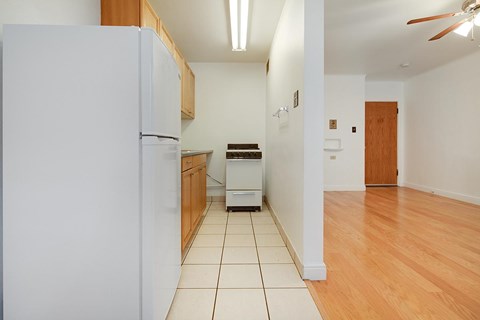 A kitchen with white appliances and wooden cabinets.