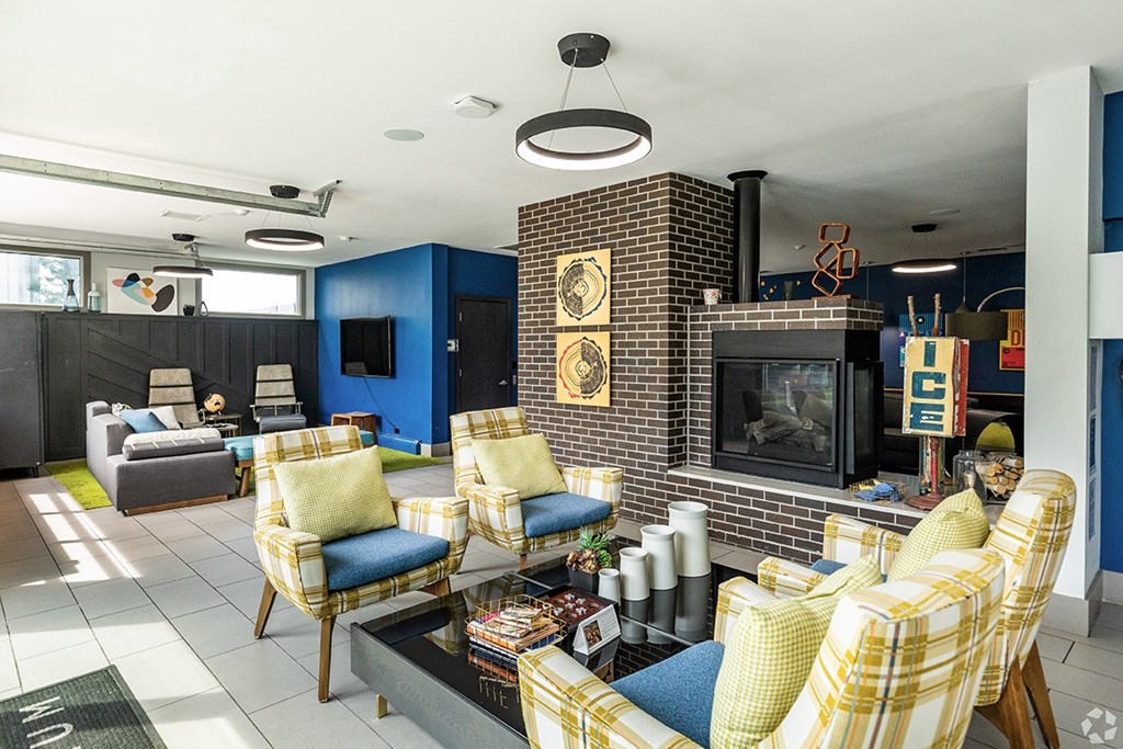 A living room with a fireplace and blue chairs.