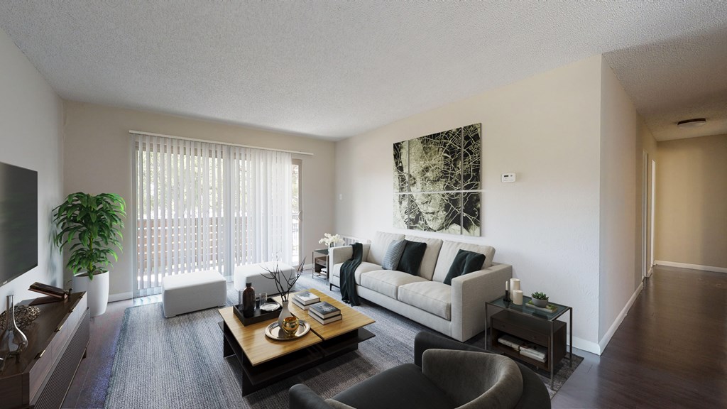 A living room with a couch, coffee table, and a plant.