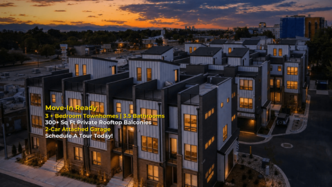 A building complex with a sign that says "Move-In Ready! 3 + Bedroom Townhomes | 2.5 Bathrooms | 300+ Sq Ft Private Rooftop Balconies | 