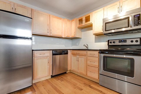 a kitchen with stainless steel appliances and wooden cabinets