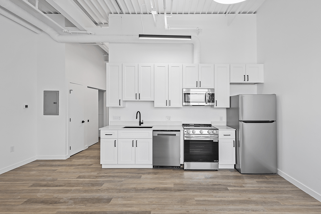 A kitchen with white cabinets and stainless steel appliances.