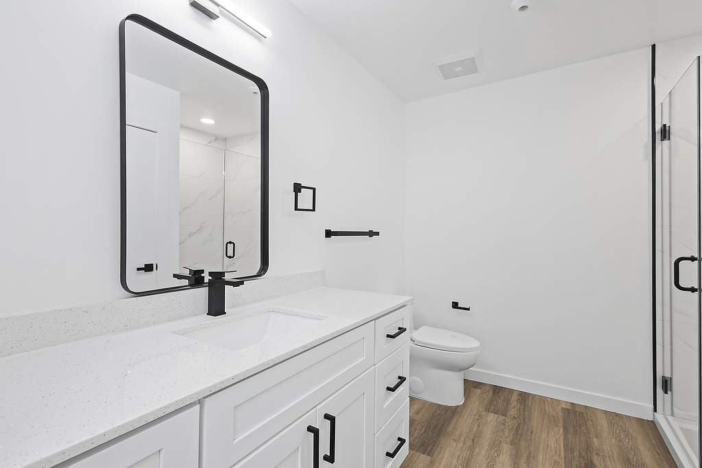 A bathroom with a white counter top and a white toilet.
