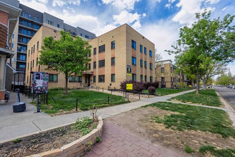 A brick building with a yellow sign in front of it.
