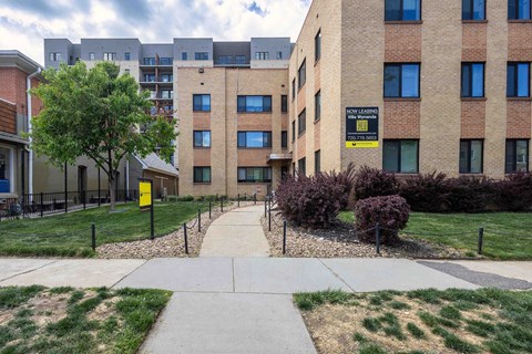 A yellow sign on a building says "No Parking Anytime.".