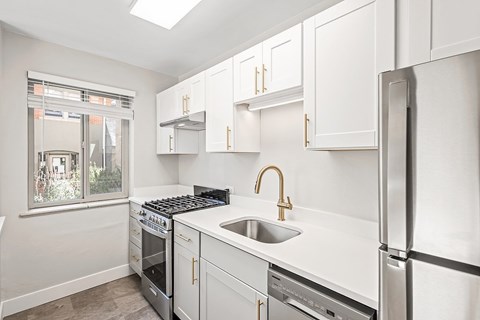 A kitchen with white cabinets and stainless steel appliances.