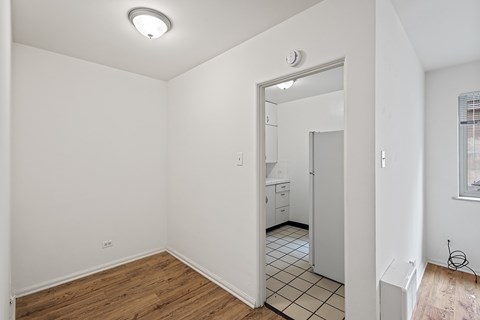 A white room with a doorway leading to another room.