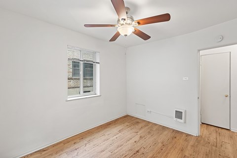 A room with a ceiling fan and a window.