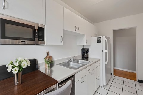 A kitchen with white cabinets and a black counter top.