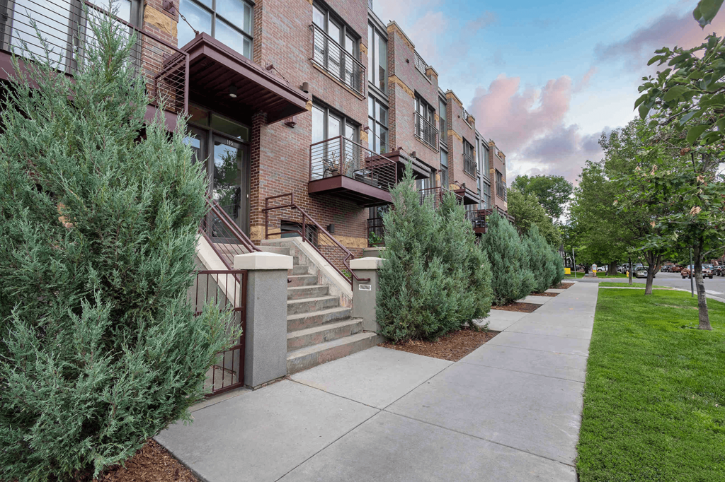 a sidewalk in front of a building with stairs