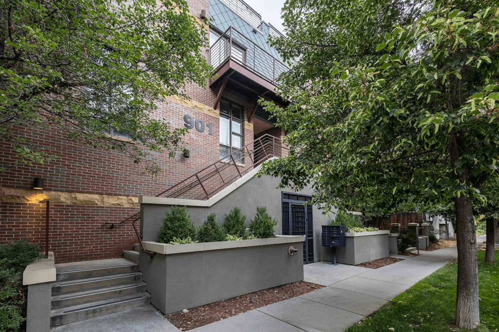 the exterior of a building with stairs and trees