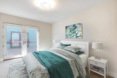 a bedroom with a bed and a door to a balcony