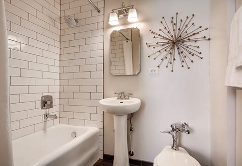 A white bathroom with a tub, sink, and toilet.
