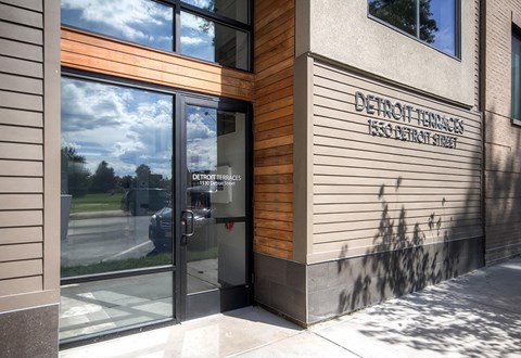 The front of a building with a glass door and a sign that reads "Detroit Tenants.".