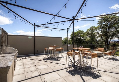 A patio with a table and chairs under string lights.