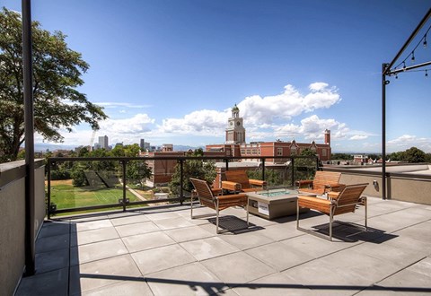 A patio with a table and chairs overlooking a cityscape.