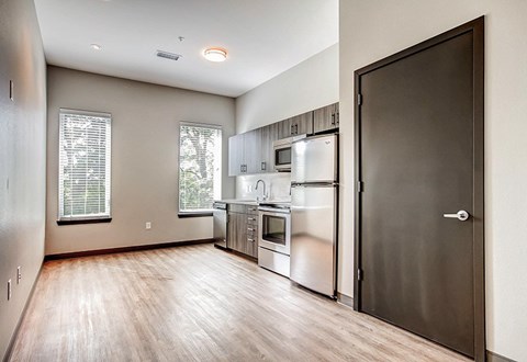 A kitchen with a refrigerator, microwave, and oven.