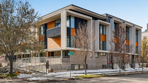 A modern building with a mix of grey and orange accents.