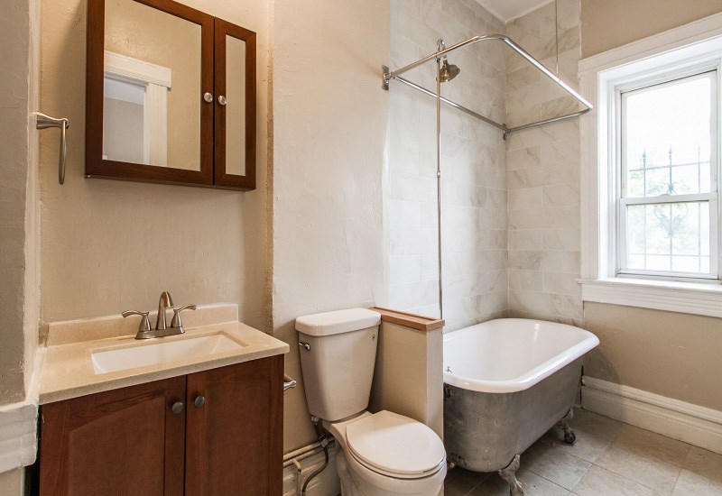 A bathroom with a toilet, sink, and tub.