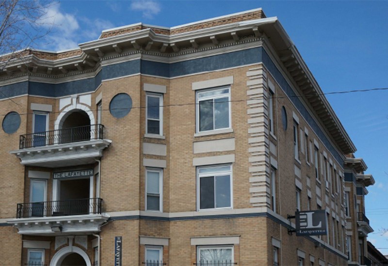 A building with a balcony on the first floor.