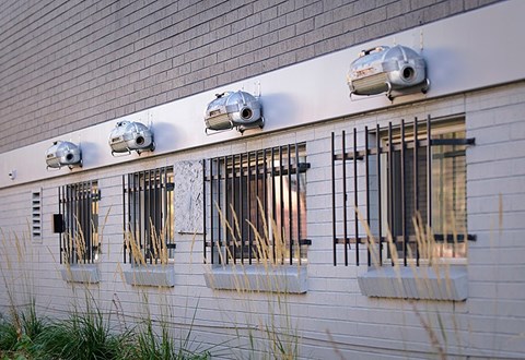 A white building with four black metal bars on the windows.