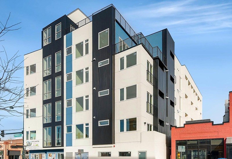 A modern multi-story building with black, white, and blue panels.