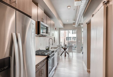 A modern kitchen with stainless steel appliances and wooden cabinets.