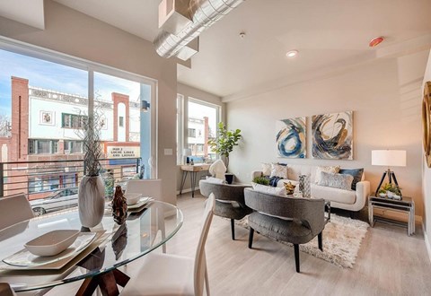 A modern living room with a glass table and chairs.