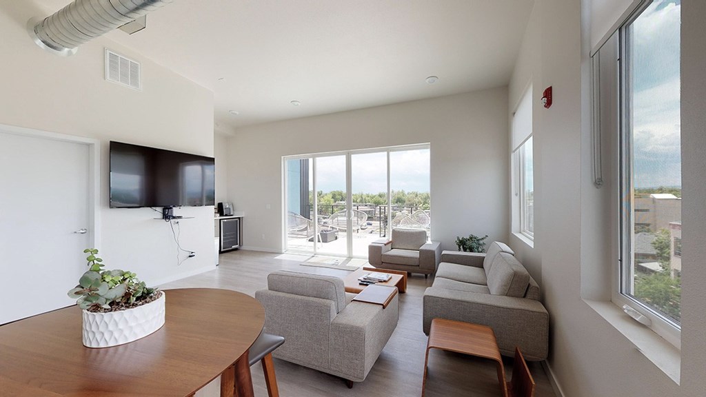 A living room with a grey couch and a wooden table.
