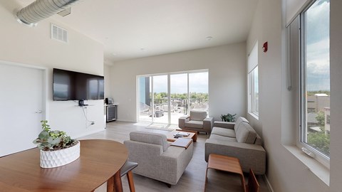 A living room with a grey couch and a wooden table.