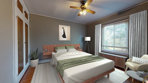 A bedroom with a bed, a chair, and a ceiling fan.