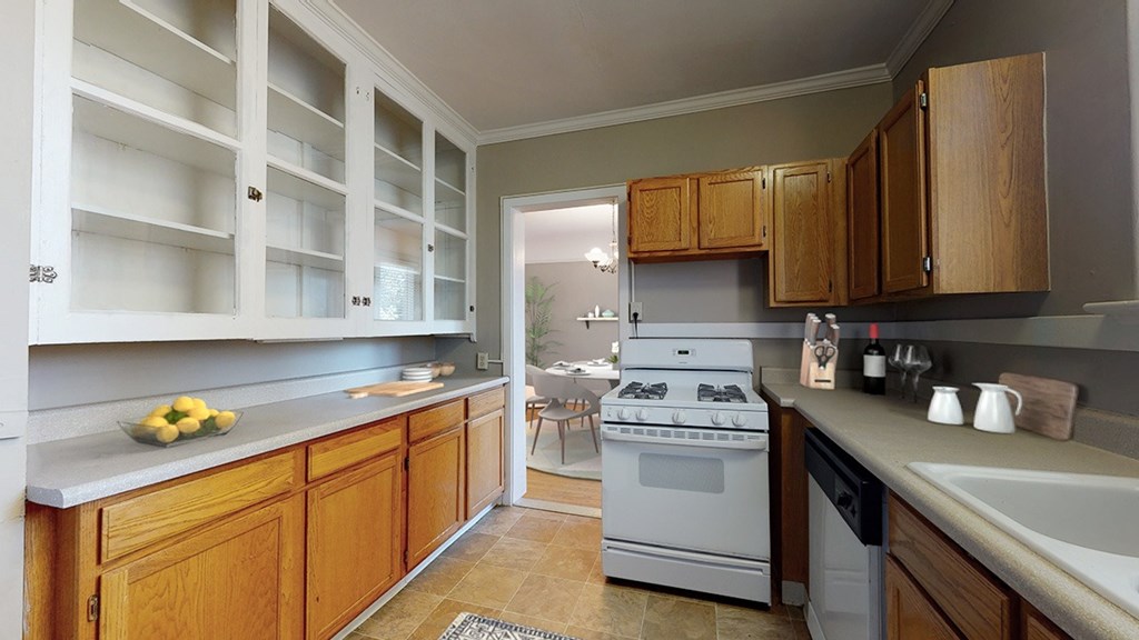 A kitchen with wooden cabinets and a white stove top oven.