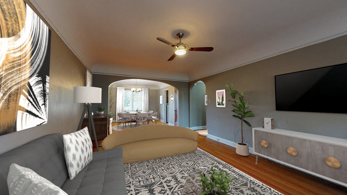 A living room with a grey couch and a patterned rug.
