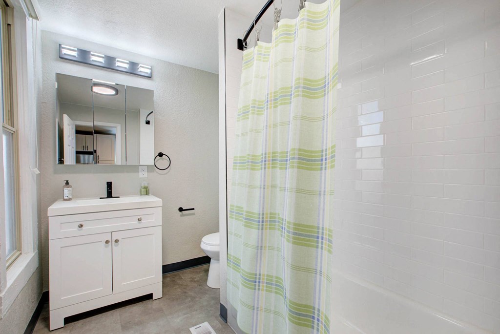 a bathroom with a shower and a sink and a toilet