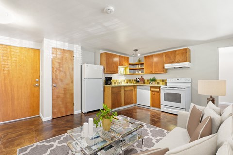 a kitchen and living room with white appliances and wooden cabinets