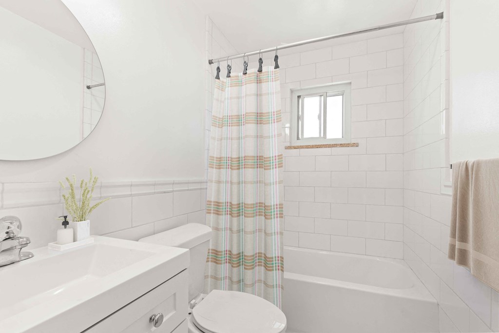 a white bathroom with a shower curtain and a toilet