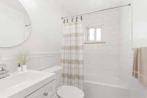 a white bathroom with a shower curtain and a toilet