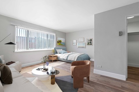 a bedroom with a bed and a living room with a table and chairs