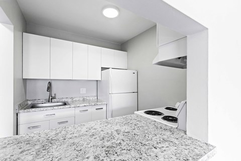 a kitchen with white appliances and granite counter tops