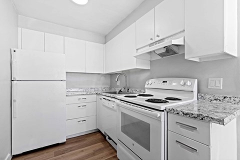 a white kitchen with white appliances and marble counter tops