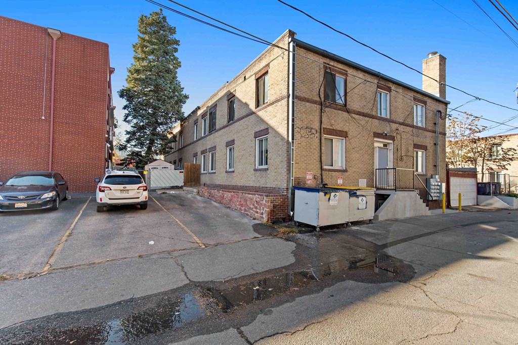 A brick building with a parking lot in front of it.