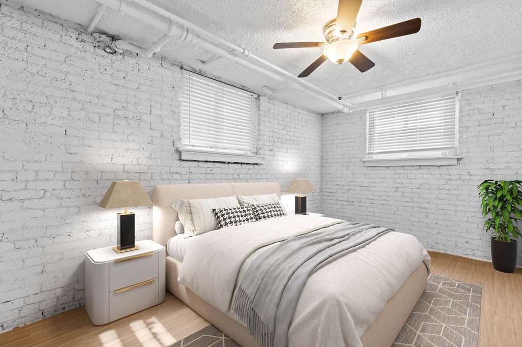 A bedroom with a bed, nightstand, and a ceiling fan.