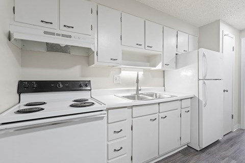 a white kitchen with white appliances and white cabinets