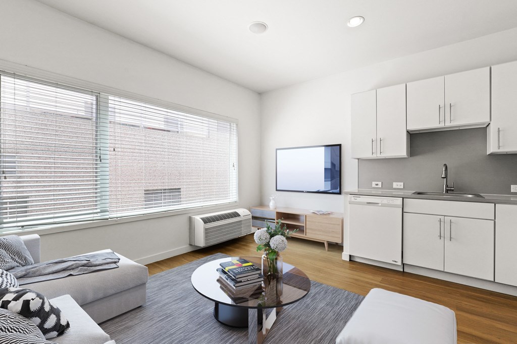 a living room with white walls and a large window