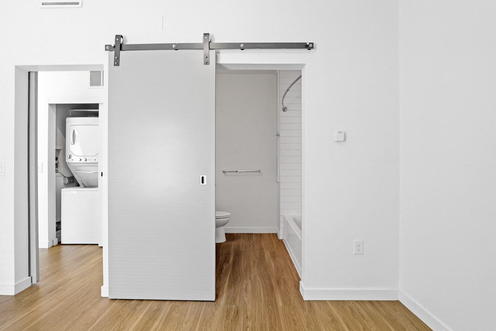 a white bathroom with a white toilet and white walls