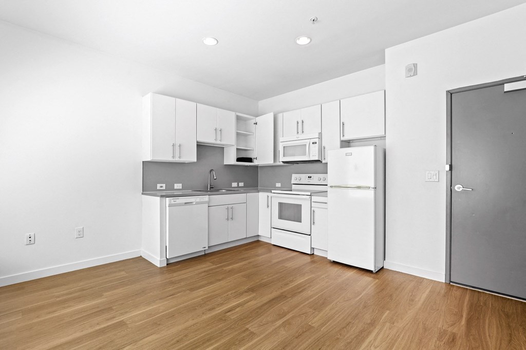 a kitchen with white cabinetry and a wooden floor